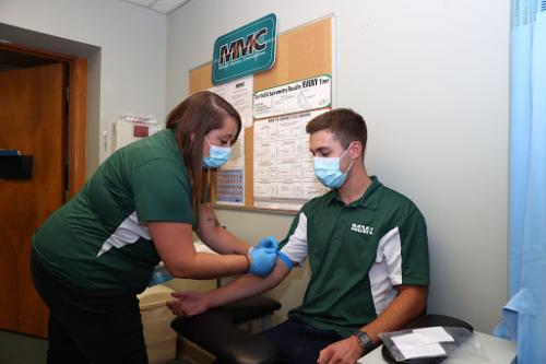 Blood being drawn during an employee health screening

