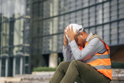 avoiding burnout in the workplace construction worker sits with head in hands overwhelmed mobile medical corporation 